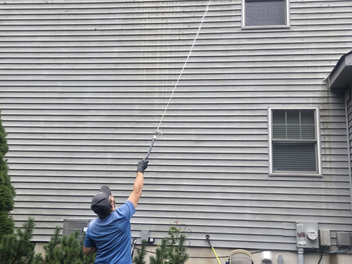Doyle's Professional Services team soft washing a house exterior